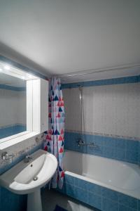 ein Badezimmer mit einem Waschbecken und einer Badewanne in der Unterkunft Delphian Colors - Blue Edition in Delphi