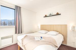 a hotel room with a bed and a window at Résidence Pierre & Vacances Les Bergers in L'Alpe-d'Huez