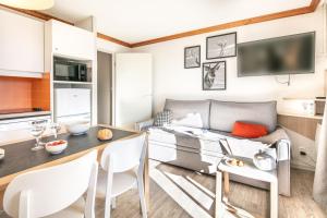 - un salon avec un canapé et une table dans l'établissement Résidence Pierre & Vacances Les Bergers, à L'Alpe-d'Huez