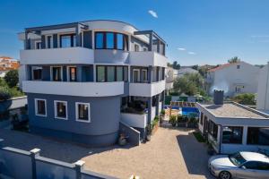 a house with a car parked in front of it at Villa Mariella in Novalja