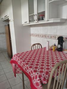a kitchen with a red and white table and chairs at Pousadinha Sophia Verde in Goiânia