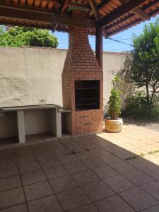 a brick fireplace with a bench on a patio at Pousadinha Sophia Verde in Goiânia
