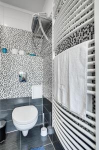 a bathroom with a white toilet and a shower at Magdi Vendégház in Celldömölk