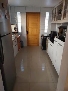 Il comprend une cuisine équipée d'un réfrigérateur et une porte en bois. dans l'établissement Casa Rural Poblado de Acha Arica, à Arica