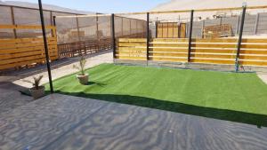 a batting cage with green turf on a tennis court at Casa Rural Poblado de Acha Arica in Arica