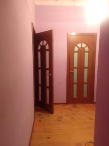 2 puertas en una habitación con suelo de madera en Guesthouse Luka, en Ushguli