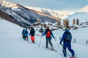 un grupo de personas esquiando por una montaña cubierta de nieve en Guesthouse Luka, en Ushguli