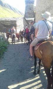 un grupo de gente montando caballos por un camino de tierra en Guesthouse Luka, en Ushguli