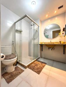 uma casa de banho com um chuveiro, um WC e um espelho. em Apto a 200m do mar em Niteroi Rio de Janeiro em Niterói