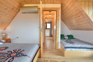 two beds in a small room with wooden ceilings at Góralski Domek Tomek in Ciche