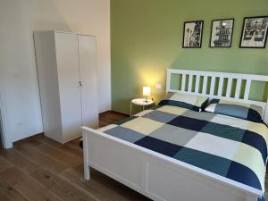 a bedroom with a bed with a blue and white comforter at Accogliente bilocale comodo per aeroporto e centro in Caselle Torinese