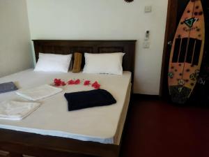 - une chambre avec un lit orné de fleurs rouges dans l'établissement LEON PARADISE SURF BEACH, à Matara