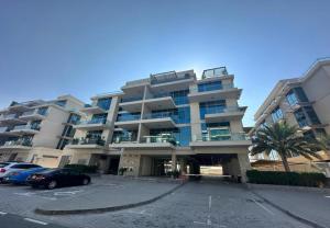 a large building with cars parked in a parking lot at EasyGo - Polo Residence 1 Bedroom Community View in Dubai
