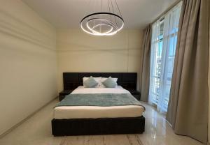 een slaapkamer met een bed en een groot raam bij EasyGo - Polo Residence 1 Bedroom Community View in Dubai