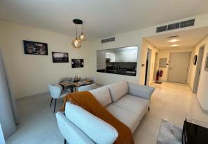 a living room with a couch and a table at EasyGo - Polo Residence 1 Bedroom Community View in Dubai