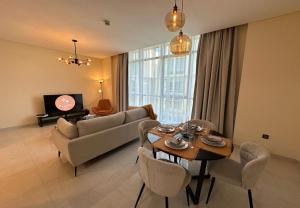 een woonkamer met een bank en een tafel bij EasyGo - Polo Residence 1 Bedroom Community View in Dubai
