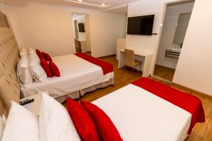Habitación de hotel con 2 camas y escritorio en Granlago Hotel en Pouso Alegre