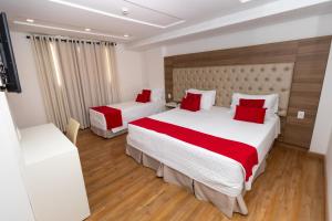 Habitación de hotel con 2 camas con almohadas rojas en Granlago Hotel, en Pouso Alegre