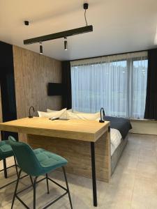 - une chambre avec un lit, une table en bois et des chaises dans l'établissement Chudodiyevo Park- Hotel, à Vyshpolʼ