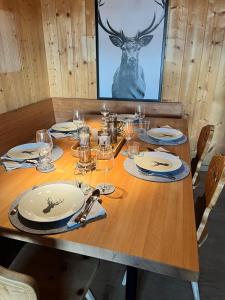 a wooden table with plates and wine glasses on it at Cozy apartment in St. Moritz in St. Moritz