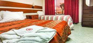 ein Hotelzimmer mit 2 Betten und Handtüchern darauf in der Unterkunft hostal keymar in Moquegua