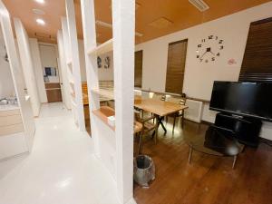 a dining room with a table and a clock on the wall at Minowa airbnb in Yubari