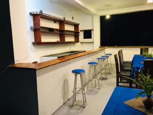 une salle de classe avec un tableau noir et un bar avec des tabourets dans l'établissement LEON PARADISE SURF BEACH, à Matara