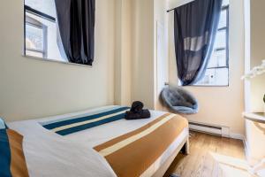 a small bedroom with a bed and a chair at Gorgeous 4BD apt in the heart of NYC in New York