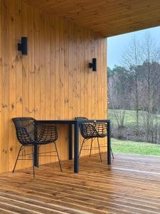 two chairs sitting at a table on a porch at Chudodiyevo Park- Hotel in Vyshpolʼ