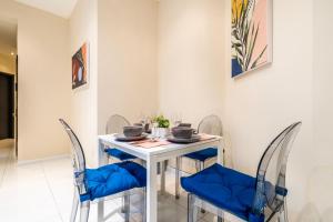 a dining room with a white table and blue chairs at Gorgeous 4BD apt in the heart of NYC in New York