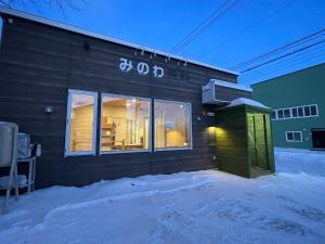 un edificio con un cartel en la nieve en Minowa airbnb en Yubari