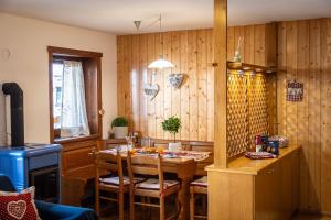 a kitchen with a table with chairs and wooden walls at Ciasa de Vich in Vigo di Fassa