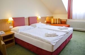 a bedroom with a large bed with towels on it at Hotel Rosner in Gablitz
