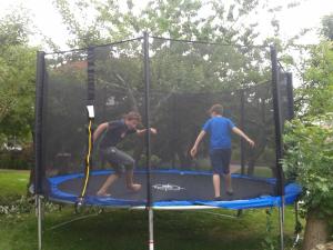 Dos hombres están jugando en un trampolín en Balkonwohnung Arngast, en Hooksiel