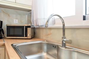uma cozinha com um lavatório e um micro-ondas em KATAKIS LUXURY APARTMENT em Chania Town