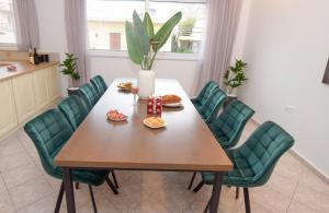 uma sala de jantar com uma mesa e cadeiras verdes em KATAKIS LUXURY APARTMENT em Chania Town
