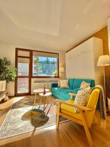 een woonkamer met een blauwe bank en een tafel bij Sunny studio close to the slopes in Borovets +33 foto's