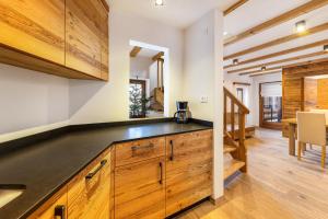 uma cozinha com armários de madeira e uma bancada em Naturoase Stegerhof Apt Vergissmeinnicht em Trodena