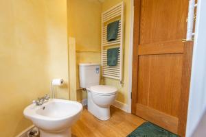 a small bathroom with a toilet and a sink at Corner Cottage - The Pink House in Southwold +10 photos