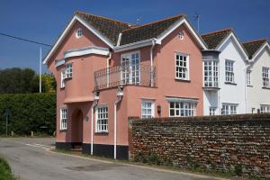 a pink house with a brick wall at Corner Cottage - The Pink House in Southwold