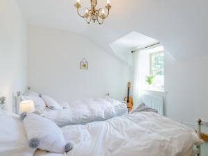 um quarto branco com 2 camas e um lustre em 2 Bed in Alnwick 78643 em Edlingham