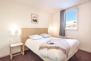 a hotel room with a bed and a window at Résidence Pierre & Vacances Les Bergers in L'Alpe-d'Huez
