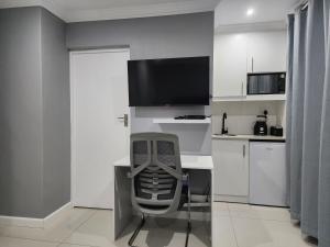 ダーバンにあるVusi's Guesthouseのキッチン(デスク、椅子、テレビ付) +12枚の写真