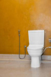 a white toilet in a bathroom with a hose at Hanka Villa -Ambalangoda in Ambalangoda