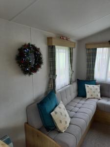 uma sala de estar com um sofá cinzento com almofadas azuis em Lindens on the Lido em Knaresborough