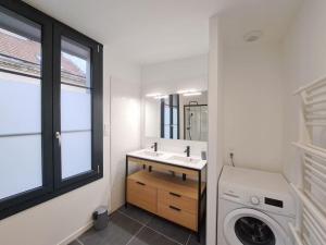 a bathroom with a sink and a washing machine at Antibes, duplex lumineux in Reims