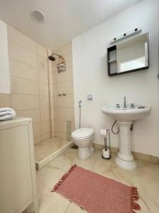 a white bathroom with a sink and a toilet at Lindo Apt Jardim Botânico in Rio de Janeiro
