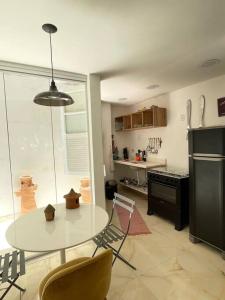 a kitchen with a table with chairs and a refrigerator at Lindo Apt Jardim Botânico in Rio de Janeiro