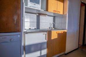 uma cozinha com um fogão, um lavatório e um micro-ondas em Flat with a view in Huez - Welkeys em LʼHuez