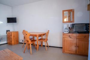 uma sala de jantar com mesa e cadeiras e uma televisão em Flat with a view in Huez - Welkeys em LʼHuez